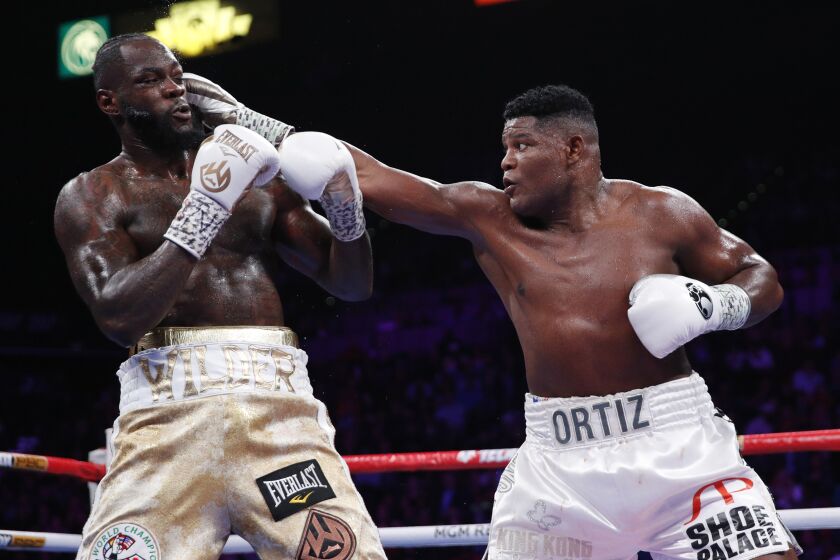 Luis Ortiz hits Deontay Wilder during the WBC heavyweight title boxing match Saturday, Nov. 23, 2019, in Las Vegas. (AP Photo/John Locher)