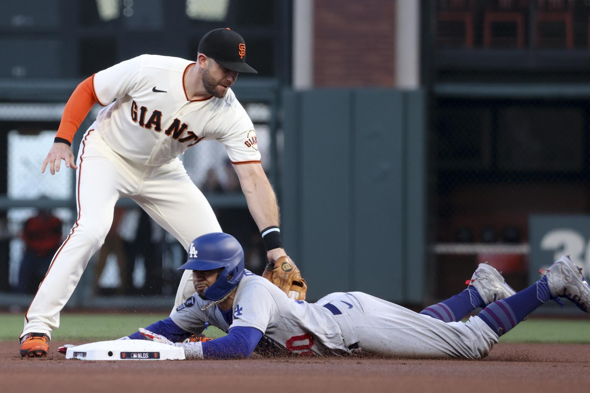 Dodgers' Mookie Betts, bottom, steals second base ahead of the tag by Giants third baseman Evan Longoria