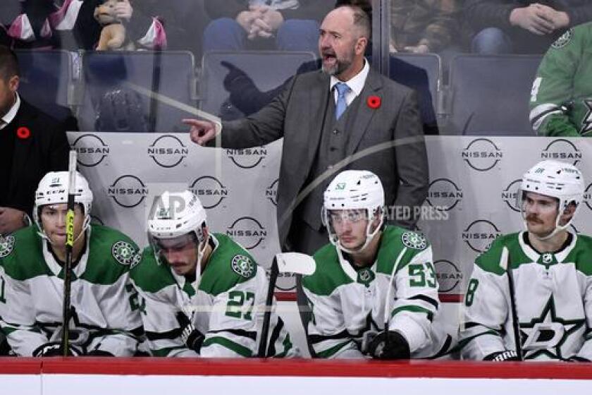 FILE - Dallas Stars' head coach Pete DeBoer, center, shouts instructions to his players against the Winnipeg Jets during the third period of an NHL hockey match in Winnipeg, Manitoba, on Saturday, Nov. 11, 2023. The Stars are heading toward the NHL playoffs with the league's most balanced scoring team. (Fred Greenslade/The Canadian Press via AP, File)