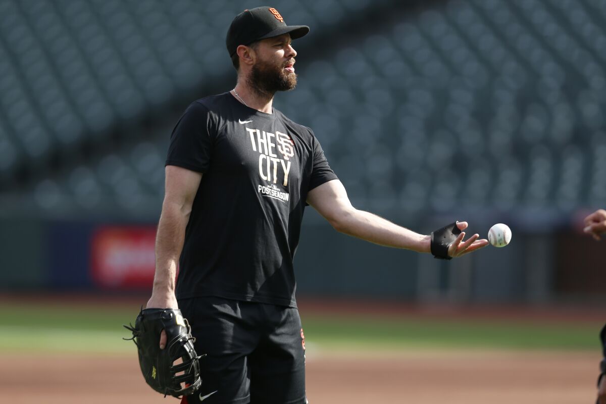 San Francisco Giants' Brandon Belt tosses a ball during a workout for the baseball team's National League Division Series against the Los Angeles Dodgers, Thursday, Oct. 7, 2021, in San Francisco. (AP Photo/Jed Jacobsohn)