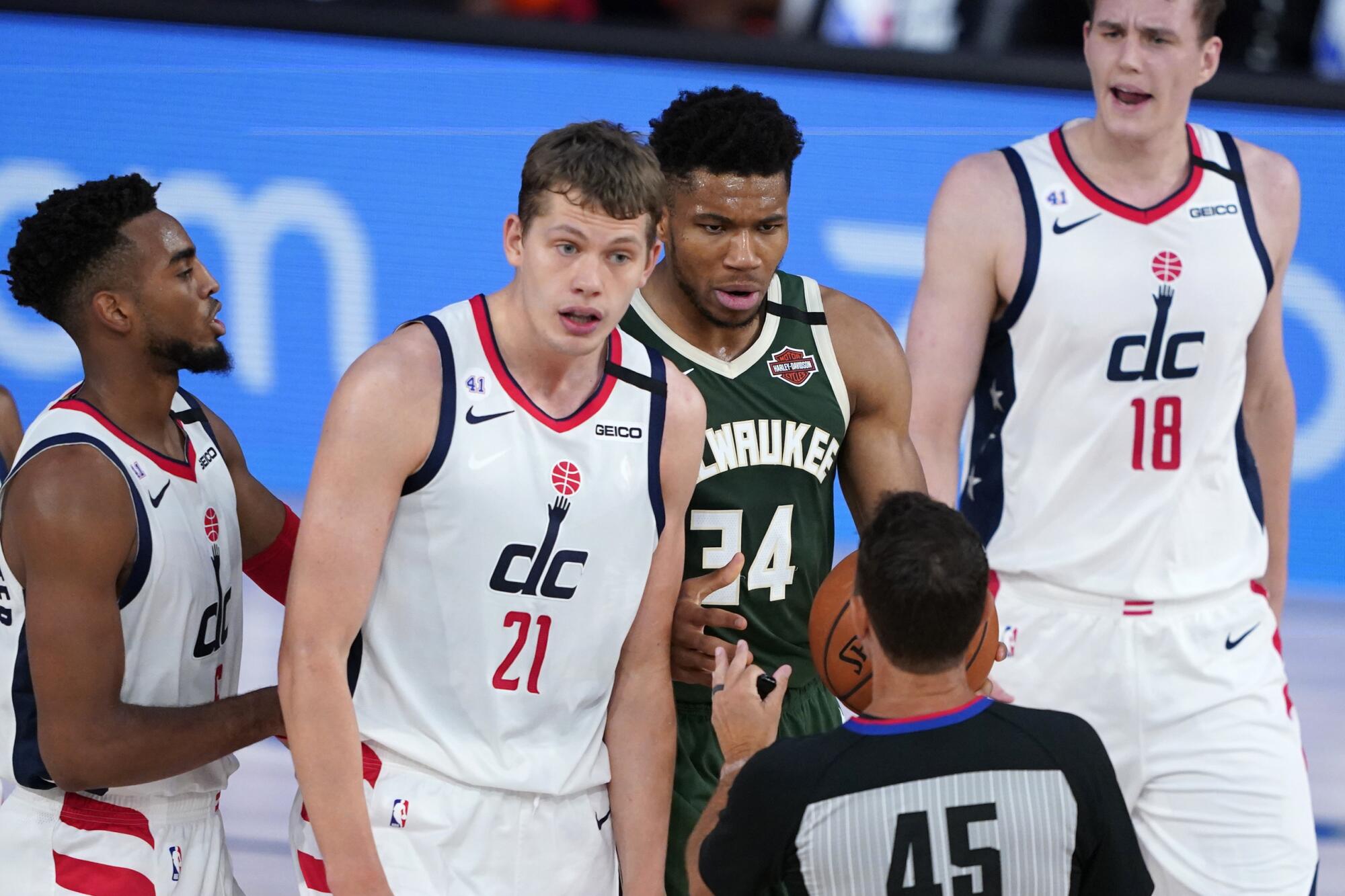 Washington's Moe Wagner and Milwaukee's Giannis Antetokounmpo seek clarification regarding a call earlier this season.