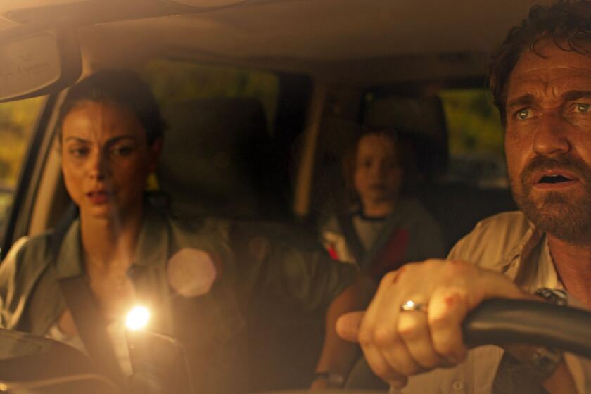 Morena Baccarin and Roger Dale Floyd in a vehicle with Gerard Butler behind the wheel in the movie "Greenland."