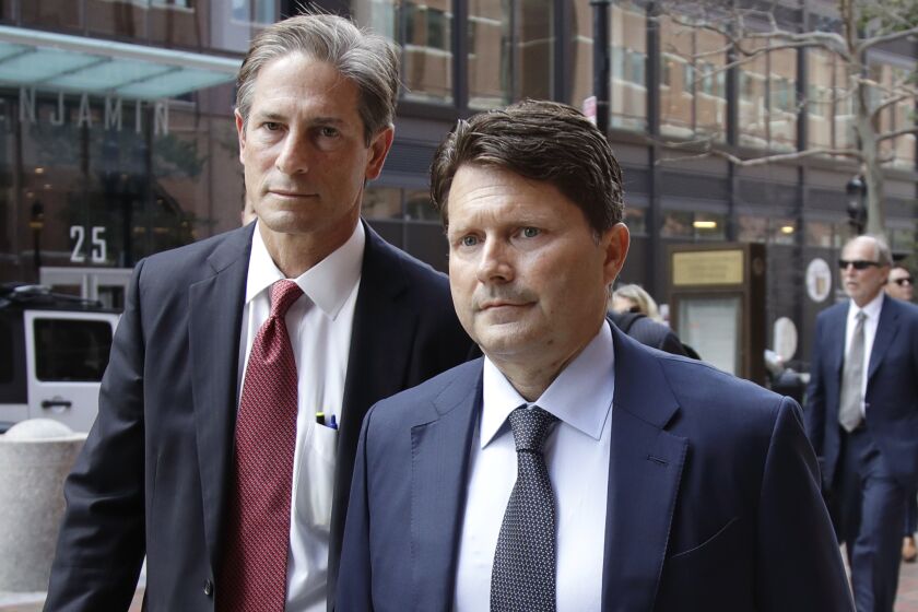 Devin Sloane, right, arrives at federal court for sentencing in a nationwide college admissions bribery scandal in Boston.