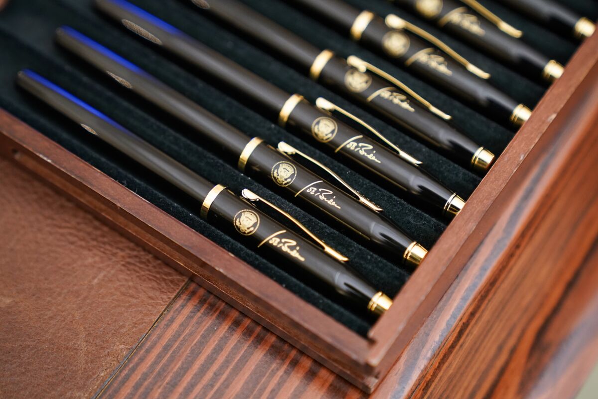 Ceremonial pens in a case feature President Biden's signature and presidential seal.
