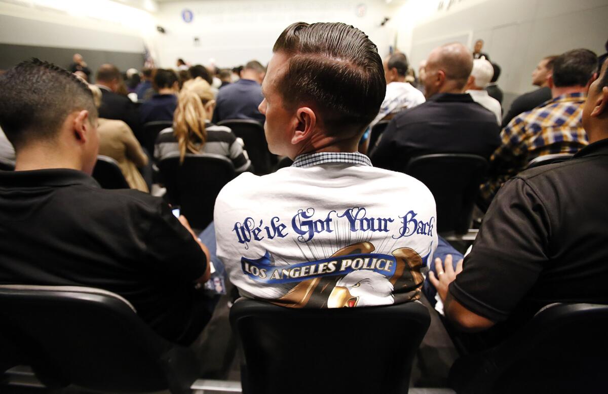 Officer Brent Lamoureux wears a shirt reading "We've Got Your Back" from the Police Protective League as a large turnout of officers spilled into the hallway outside the Police Commission board room.