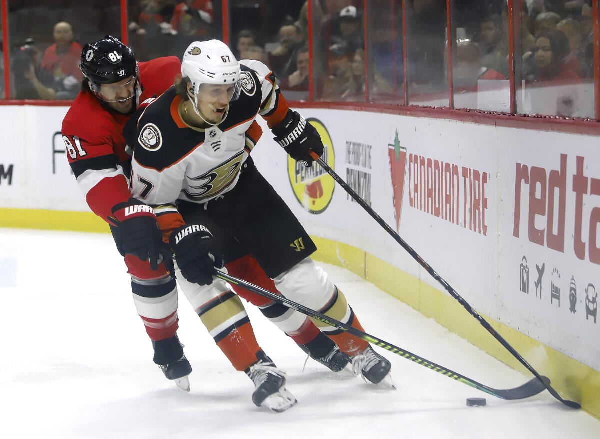 Ducks left wing Rickard Rakell and Senators center Chris Tierney battle along the boards during the first period of a game Feb. 4.