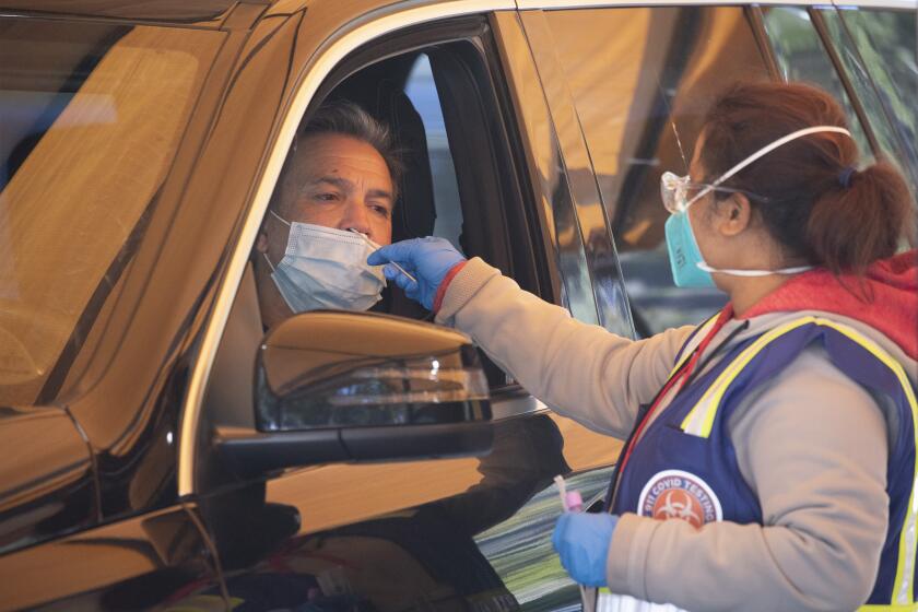 LOS ANGELES, CA - JANUARY 05: Francis Delpech gets tested at 911 COVID Testing on Sepulveda Boulevard in Los Angeles on Wednesday, Jan. 5, 2022. This site identified the first local case of "flurona." The patient was only described as a teenager. (Myung J. Chun / Los Angeles Times)