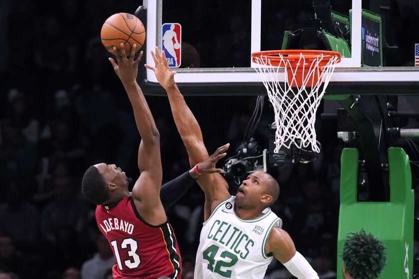 Boston Celtics center Al Horford (42) reaches to block a shot by Miami Heat center Bam Adebayo (13) during the first half of an NBA basketball game Wednesday, Nov. 30, 2022, in Boston. (AP Photo/Charles Krupa)