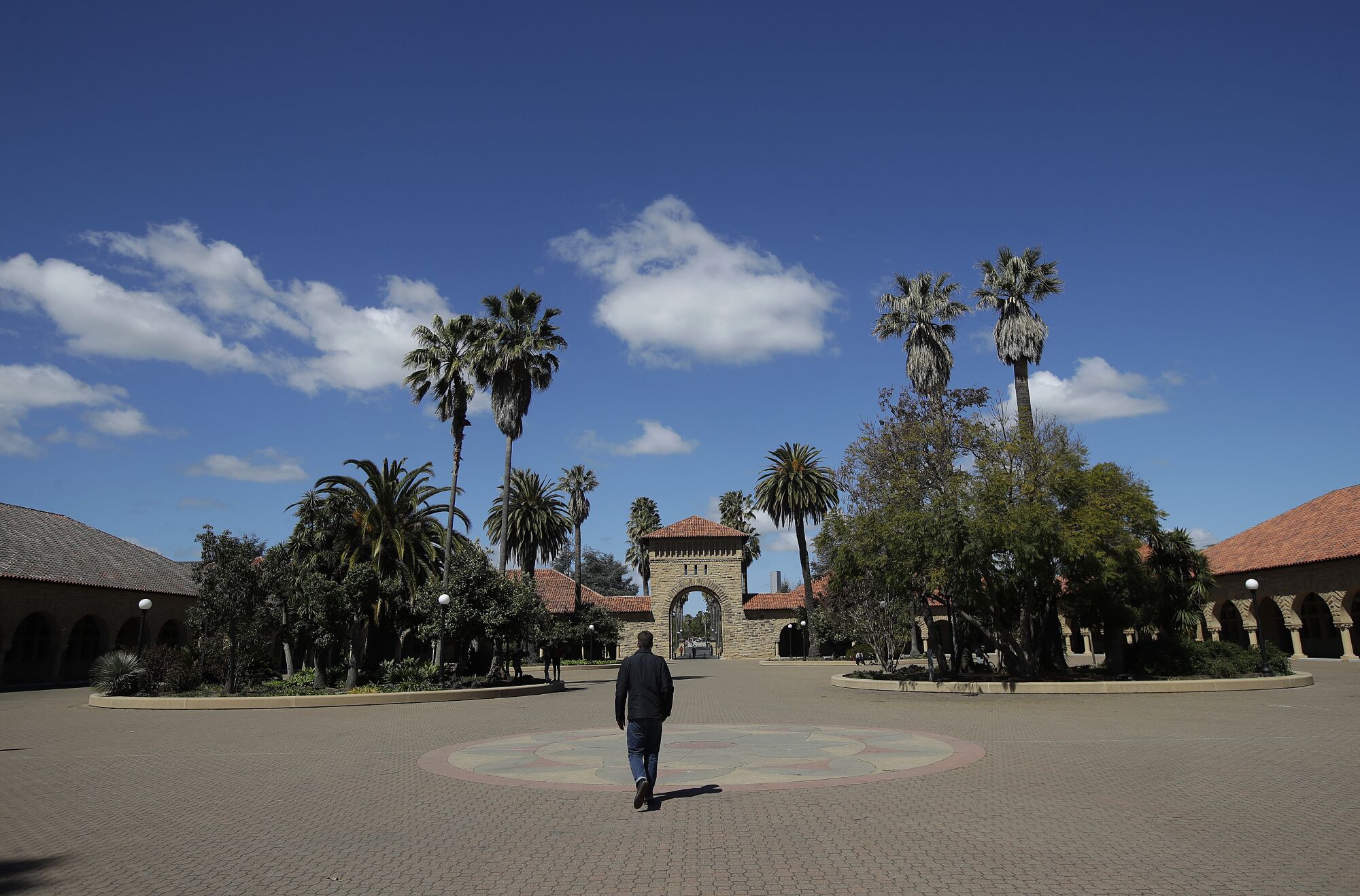 A pedestrian walks on the campus at Stanford University.