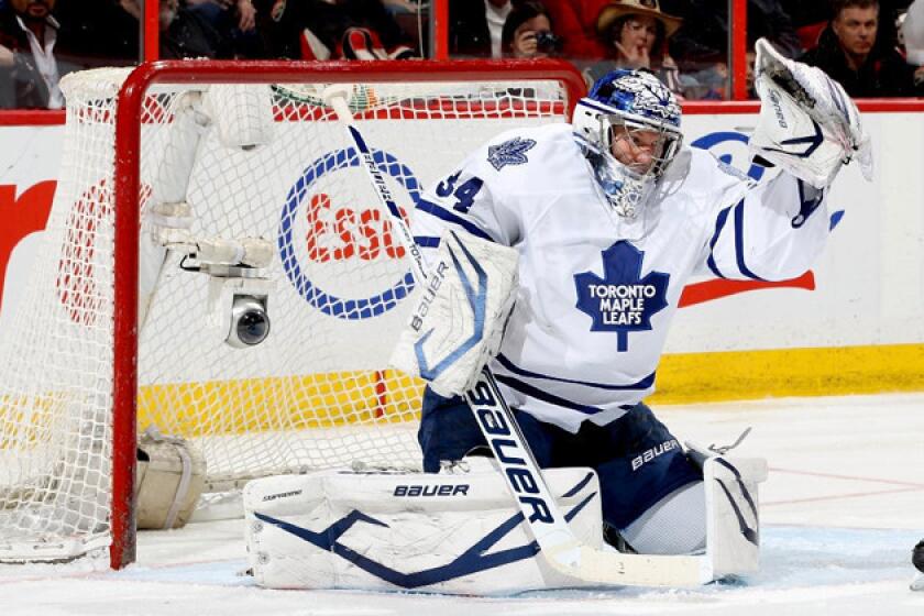 Toronto Maples Leafs goalie James Reimer makes a glove save off a tip during a game against the Ottawa Senators.