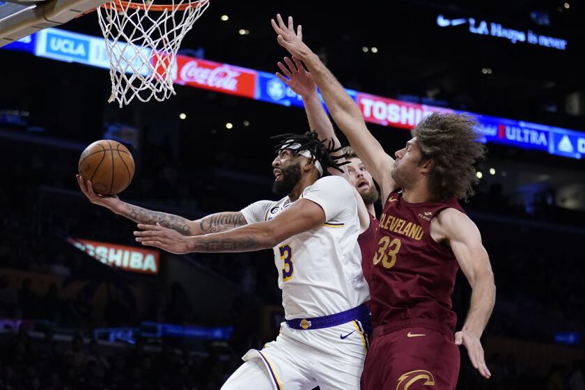 Los Angeles Lakers forward Anthony Davis (3) scores against Cleveland Cavaliers center Robin Lopez (33) during the first half of an NBA basketball game Sunday, Nov. 6, 2022, in Los Angeles. (AP Photo/Marcio Jose Sanchez)
