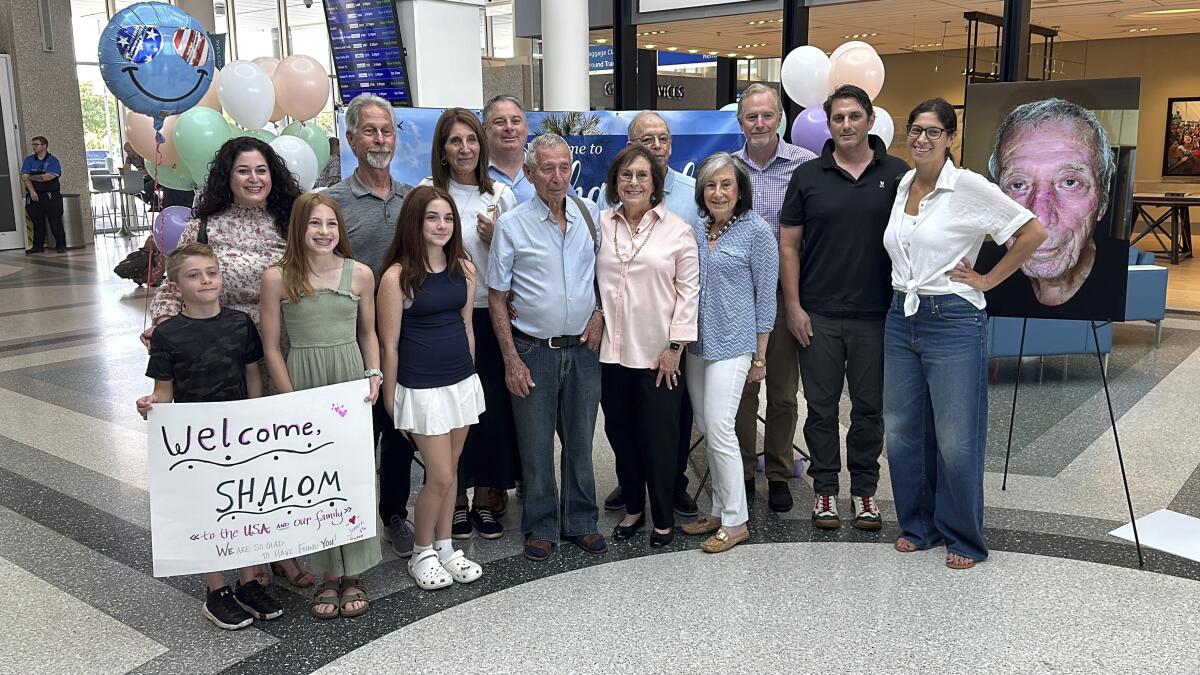 Shalom Korai poses for a picture with members of his extended family at an airport.