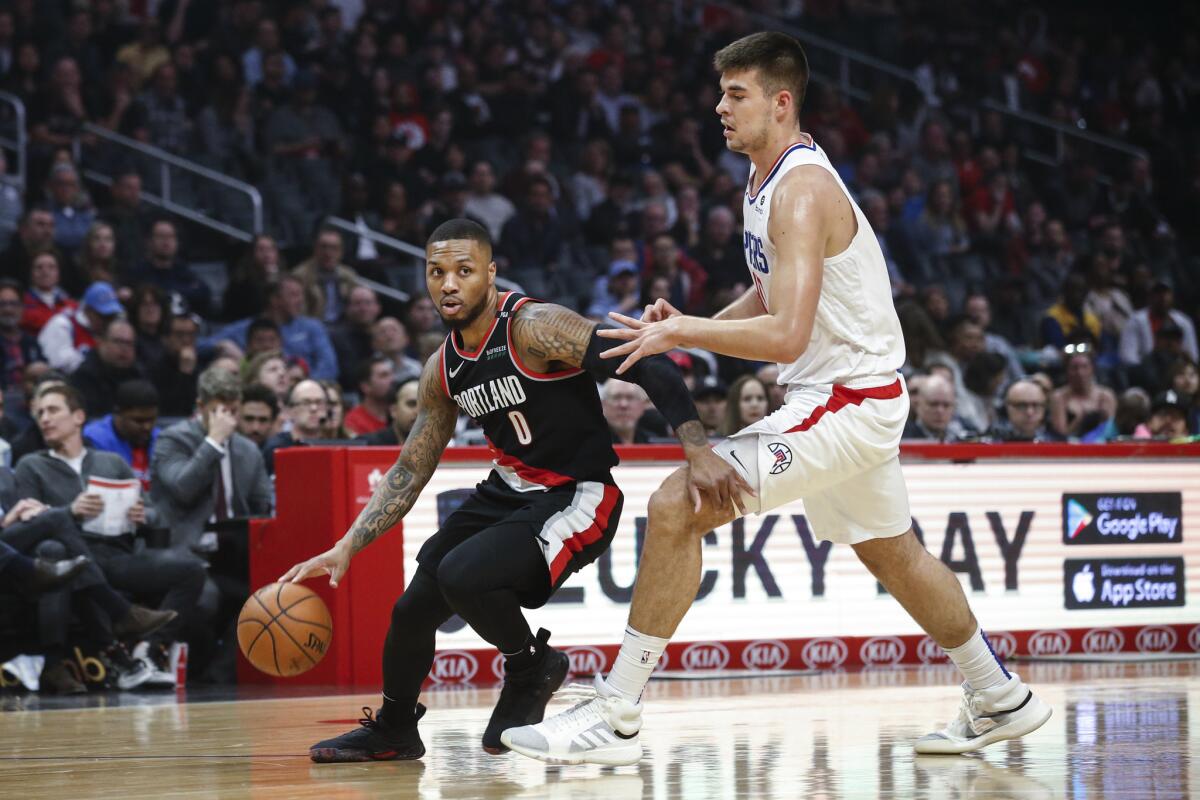 Portland Trail Blazers' Damian Lillard, left, drives against Los Angeles Clippers' Ivica Zubac during the first half of an NBA basketball game Tuesday, March 12, 2019, in Los Angeles.