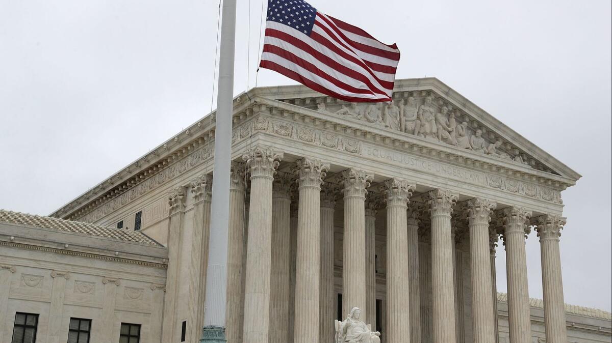 A U.S. flag flies at half-mast outside the U.S. Supreme Court on Sept. 30, 2018, in Washington, D.C.