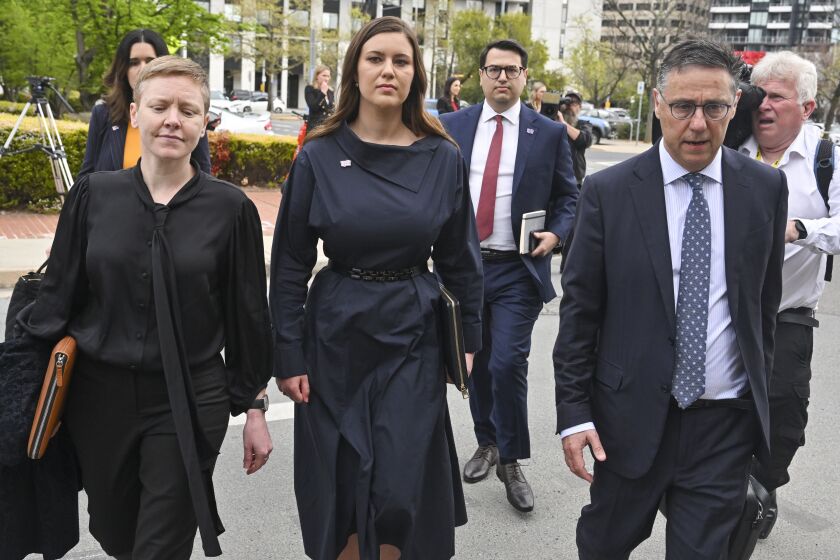 Former Liberal staffer Brittany Higgins, center, arrives at the Australian Capital Territory Supreme Court in Canberra, Australia, Tuesday, Oct. 4, 2022. A judge reminded potential jurors in a high-profile Australian rape trial on Tuesday of the importance of impartiality. Former government staffer Bruce Lehrmann is charged with raping fellow staffer Brittany Higgins in the then-Defense Industry Minister Linda Reynolds' office in Parliament House in March 2019. (Mick Tsikas/AAP Image via AP)