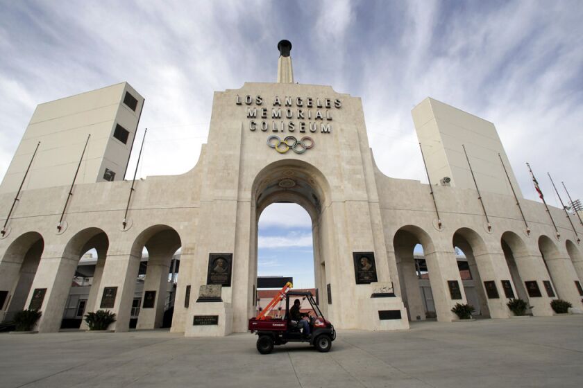A worker rides past the entrance of the Los Angeles Memorial Coliseum on Jan. 13.