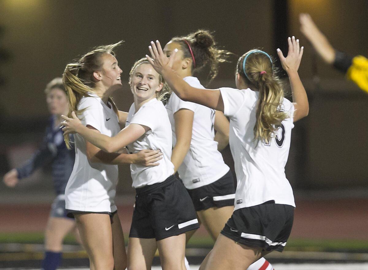 Huntington Beach High’s Jenna Nighswonger, second from left, celebrates a goal with teammates against Newport Harbor on Tuesday.