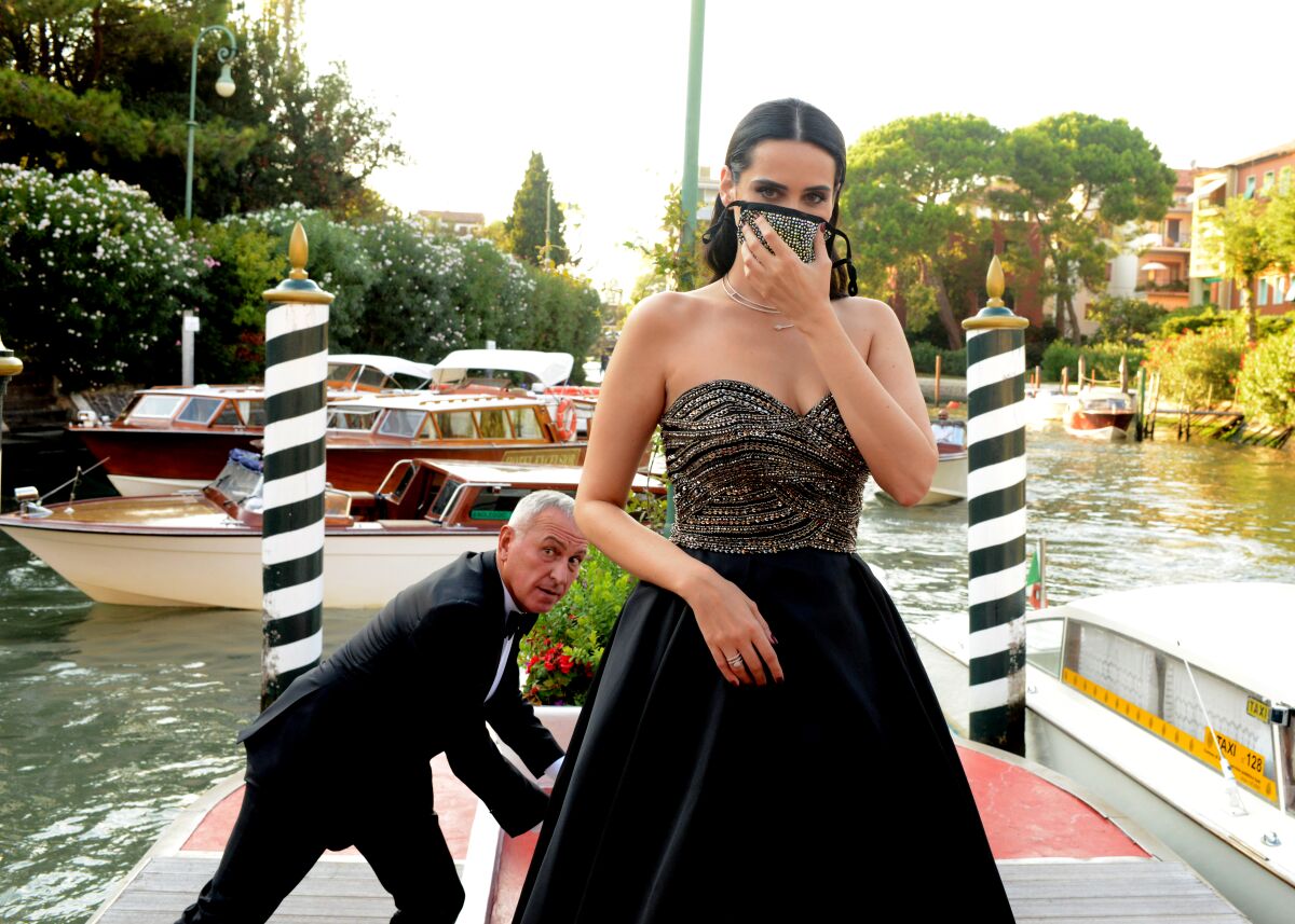 In a mask, model Catherine Poulain steps off the boat at the Excelsior Hotel for the Venice International Film Festival. 