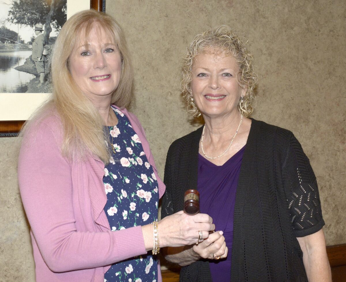 Outgoing La Providencia Guild President Sue Meckley, right, turns the presidential gavel over to Nancy Wiggins who will lead the organization through 2021.