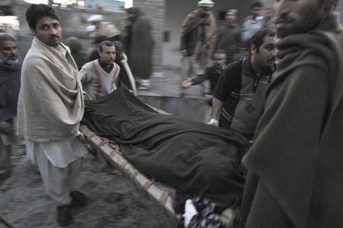 Pakistani men carry the body of a teacher who was killed Tuesday by gunmen from a hospital for burial in Swabi, Pakistan.