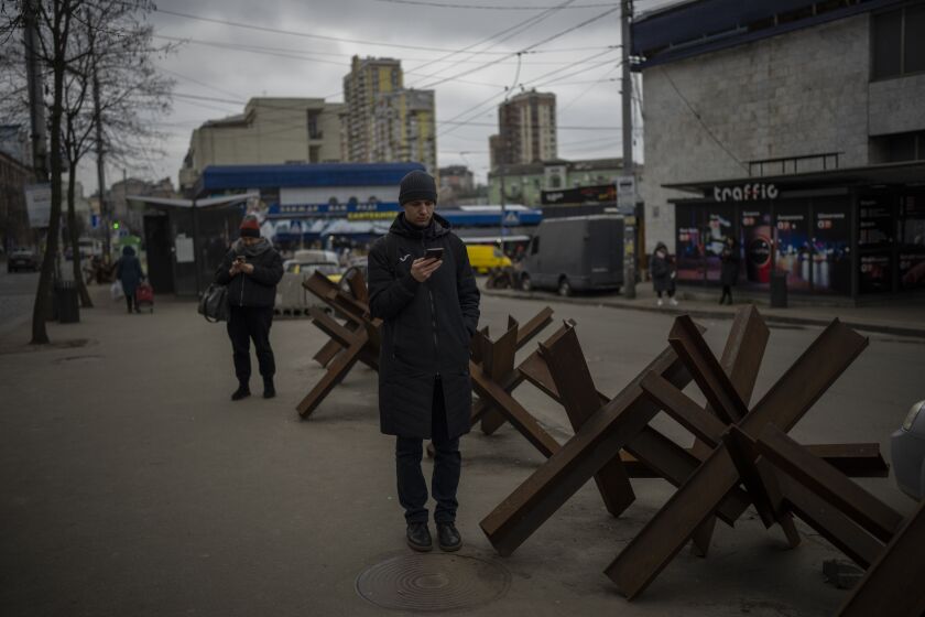Gente esperando a que llegue un autobús en Kiev, Ucrania, el lunes 30 de enero de 2023. (AP Foto/Daniel Cole)