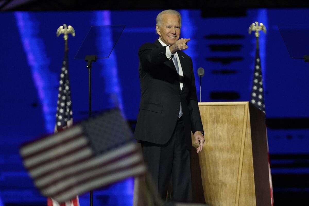 Democratic presidential candidate former Vice President Joe Biden removes his face mask as he arrives to speak Friday. 