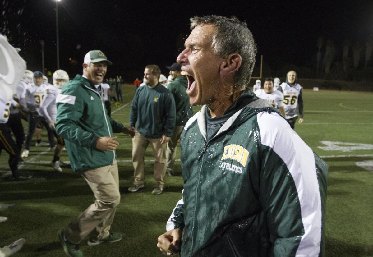 Edison High Coach Dave White celebrates after getting soaked following a 44-24 win over La Mirada in the CIF Southern Section Division 3 championship game on Friday.