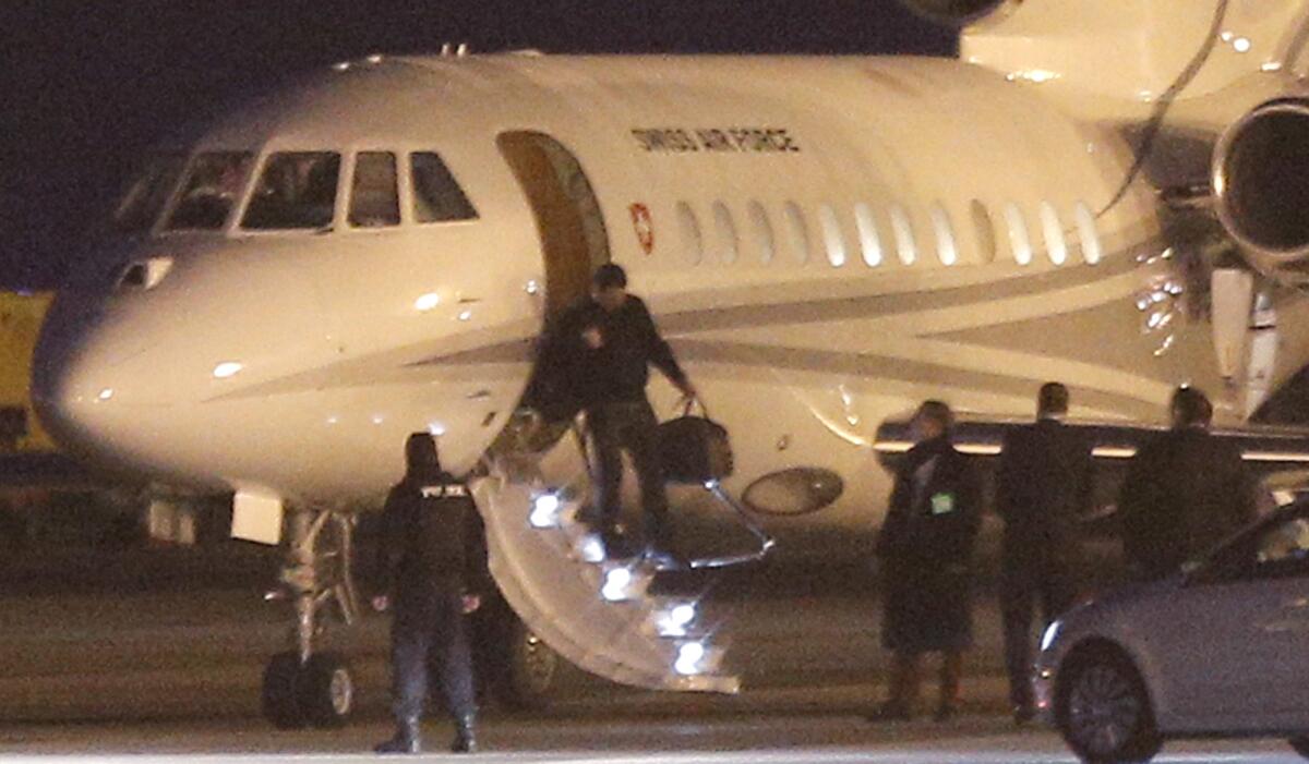 An unidentified man leaves a Swiss air force Dassault Falcon at the airport in Geneva on Sunday, as a U.S. government plane waited nearby for the men who were released from imprisonment in Iran the day before.