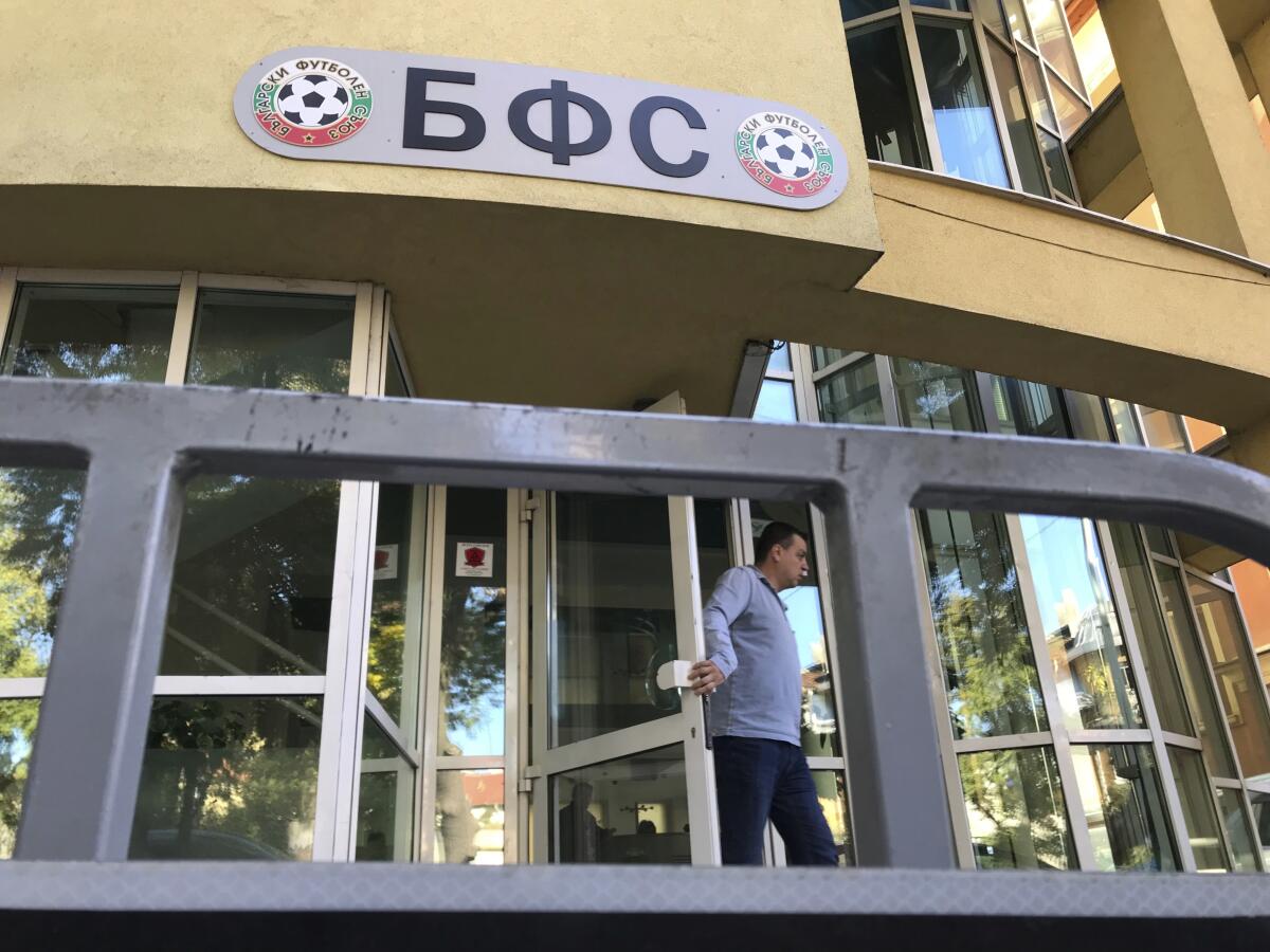 A person leaves the headquarters of the Bulgarian Football union, in Sofia, Tuesday, Oct. 15, 2019. Criticized around Europe for the racist behavior of Bulgarian fans and under pressure from the country's prime minister following a run of poor results, the president of the country's soccer federation resigned on Tuesday. (AP Photo/Valentina Petrova)
