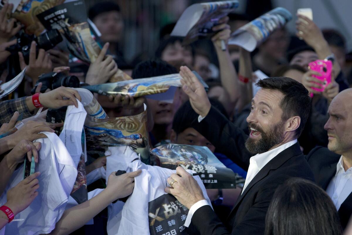 Actor Hugh Jackman signs autographs for fans during the red carpet for "X-Men: Days of Future Past" in Beijing, China.