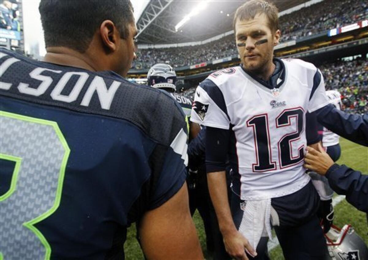 New England Patriots quarterback Tom Brady (12) talks with Seattle Seahawks quarterback Russell Wilson after an NFL football game, Sunday, Oct. 14, 2012, in Seattle. The Seahawks won 24-23. (AP Photo/Elaine Thompson)