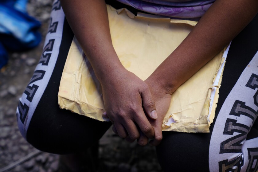 A Honduran woman clutches her asylum files while waiting in Tijuana 