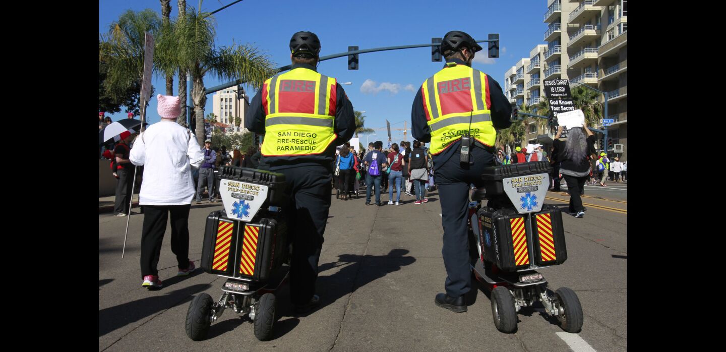 Firefighter/paramedic Thomas Woods, right, and Capt. Matt Spicer, who are with the San Diego Fire Department, follow the crowd at the back of the march in case someone needs medical assistance.