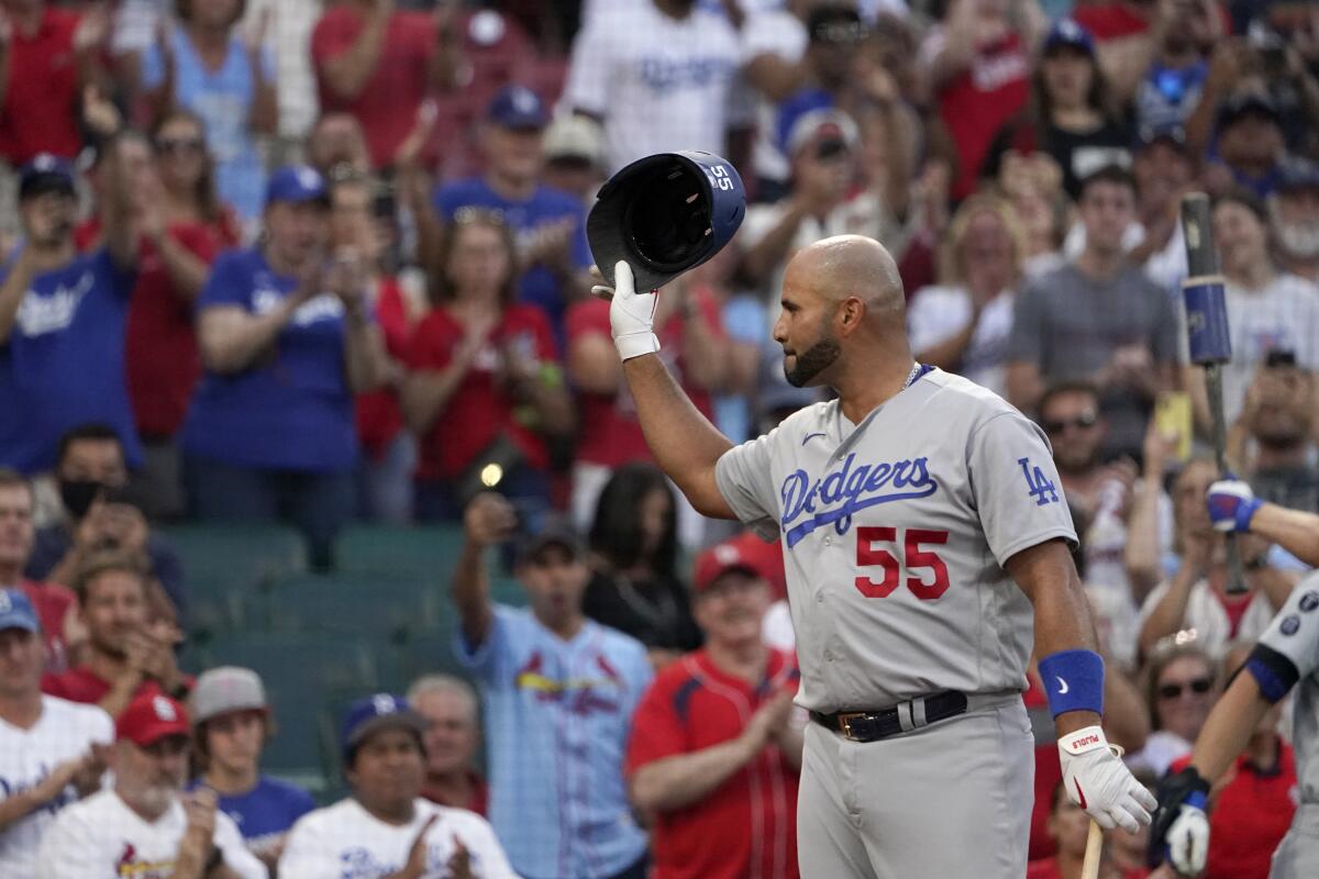 The Dodgers' Albert Pujols tips his tap to cheering fans as he steps up to bat.