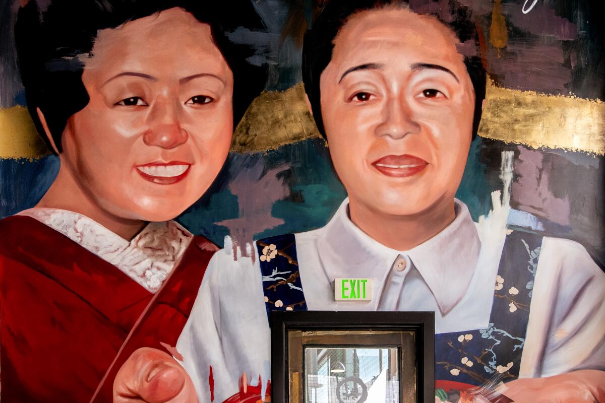 A mural depicting two women smiling while one of them holds a picture frame