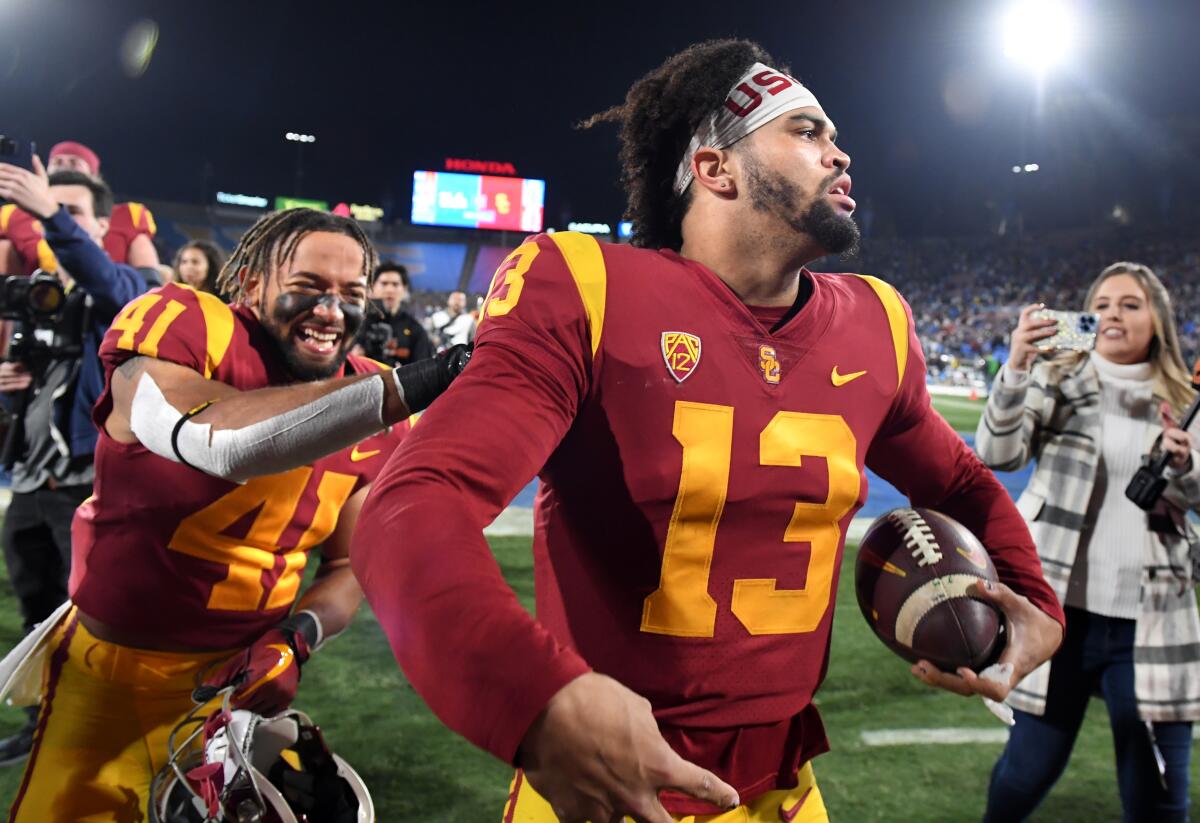 USC quarterback Caleb Williams celebrates with teammates after beating UCLA