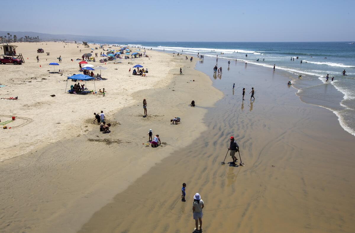 Stan Ross walks among beachgoers by the Newport Beach Pier on Wednesday.