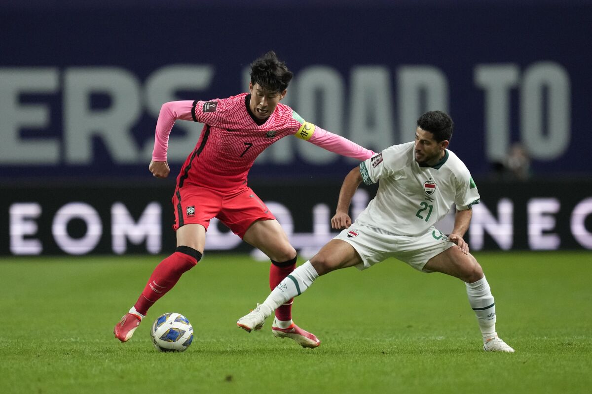 South Korea's Son Heung-min fights for the ball against Iraq's Sherko Kareem Gubari during the final round of their Asian zone group A qualifying soccer match for the FIFA World Cup Qatar 2022 at Seoul World Cup stadium in Seoul, South Korea, Thursday, Sept. 2, 2021. (AP Photo/Lee Jin-man)
