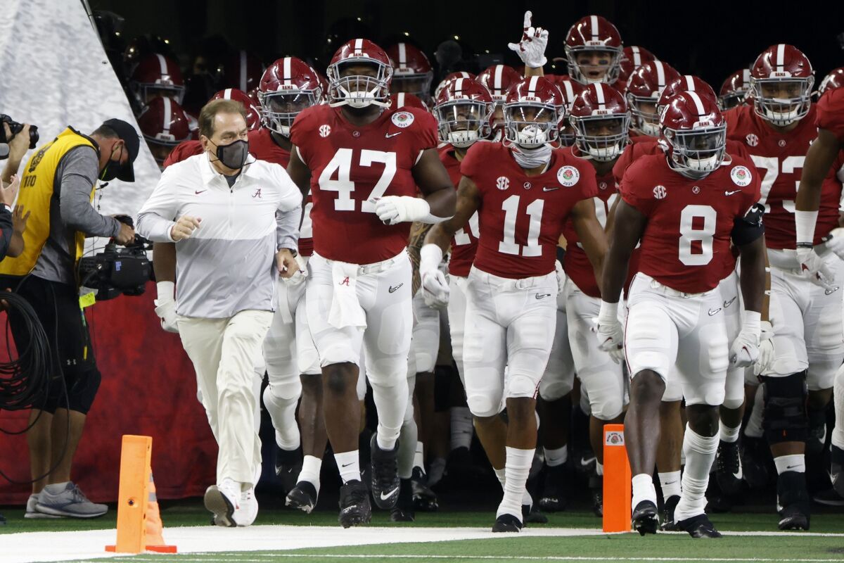 Alabama coach Nick Saban jogs onto the field with his players before beating Notre Dame in the Rose Bowl game.