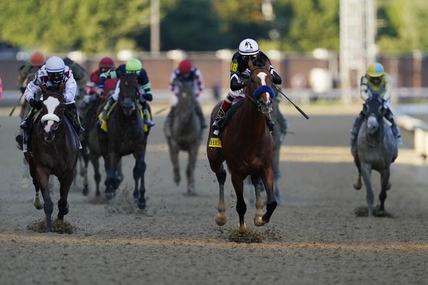 Jockey John Velazquez riding Authentic, second right, leads the field to win the 146th running of the Kentucky Derby.