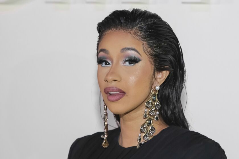 FILE - In this Wednesday, Sept. 5, 2018 file photo, Cardi B attends the Tom Ford SS19 Show at the Park Avenue Armory during New York Fashion Week in New York. Hundreds of people have lined up in New York City as the rapper handed out free winter coats. The Bronx-born rapper met with residents and fans on Thursday, Oct. 18, 2018 at the Marlboro Houses in Brooklyn during brisk fall weather. The 26-year-old also was given balloons and a cake to celebrate her recent birthday. (Photo by Brent N. Clarke/Invision/AP, File)