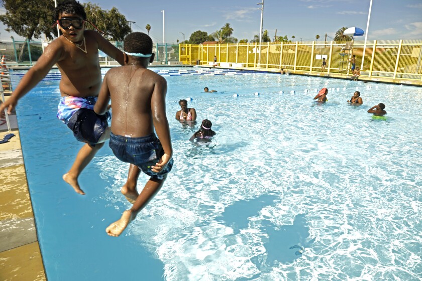 Kids wearing goggles jump into a swimming pool