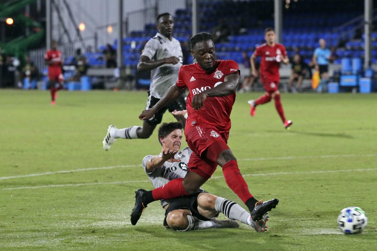 FILE - Toronto FC forward Ayo Akinola, front, scores his second goal of the game during the first half of an MLS soccer match against the Montreal Impact in Kissimmee, Fla., in this Thursday, July 16, 2020, file photo. Akinola is being talked about as a potential breakout star for the upcoming Major League Soccer season. (AP Photo/John Raoux, File)