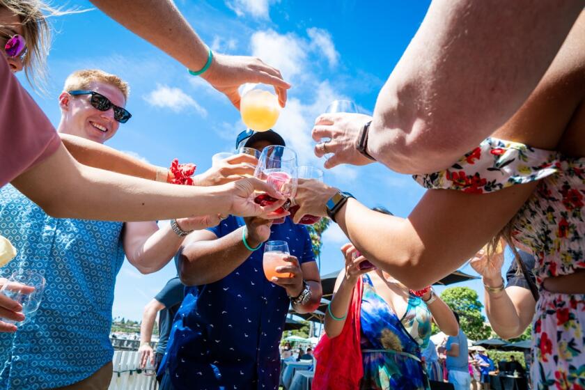 Guests raise a glass at last year's Pacific Wine & Food Classic in Newport Dunes.