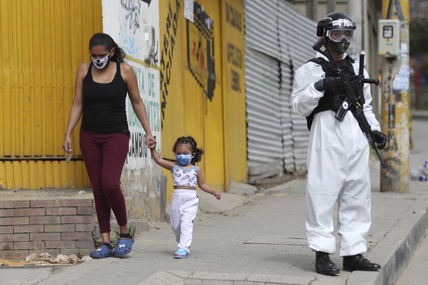 Un soldado con traje protector contra el coronavirus monta guardia el lunes 13 de julio de 2020 en Ciudad Bolivar, un área con una elevada tasa de casos, en Bogotá. (AP Foto/Fernando Vergara)