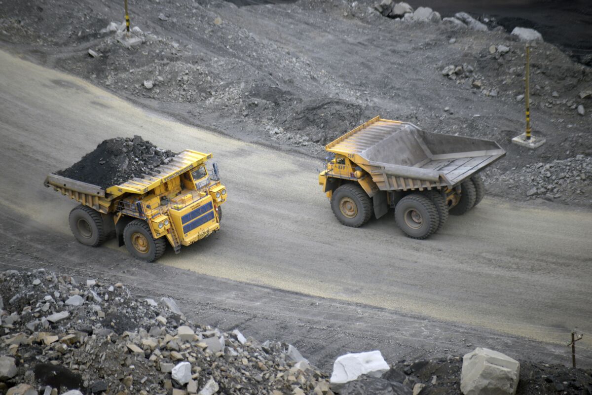  A loaded dump truck passes an empty truck as it carries away coal at an open-pit coal mine in Kemerovo, Russia in 2015.