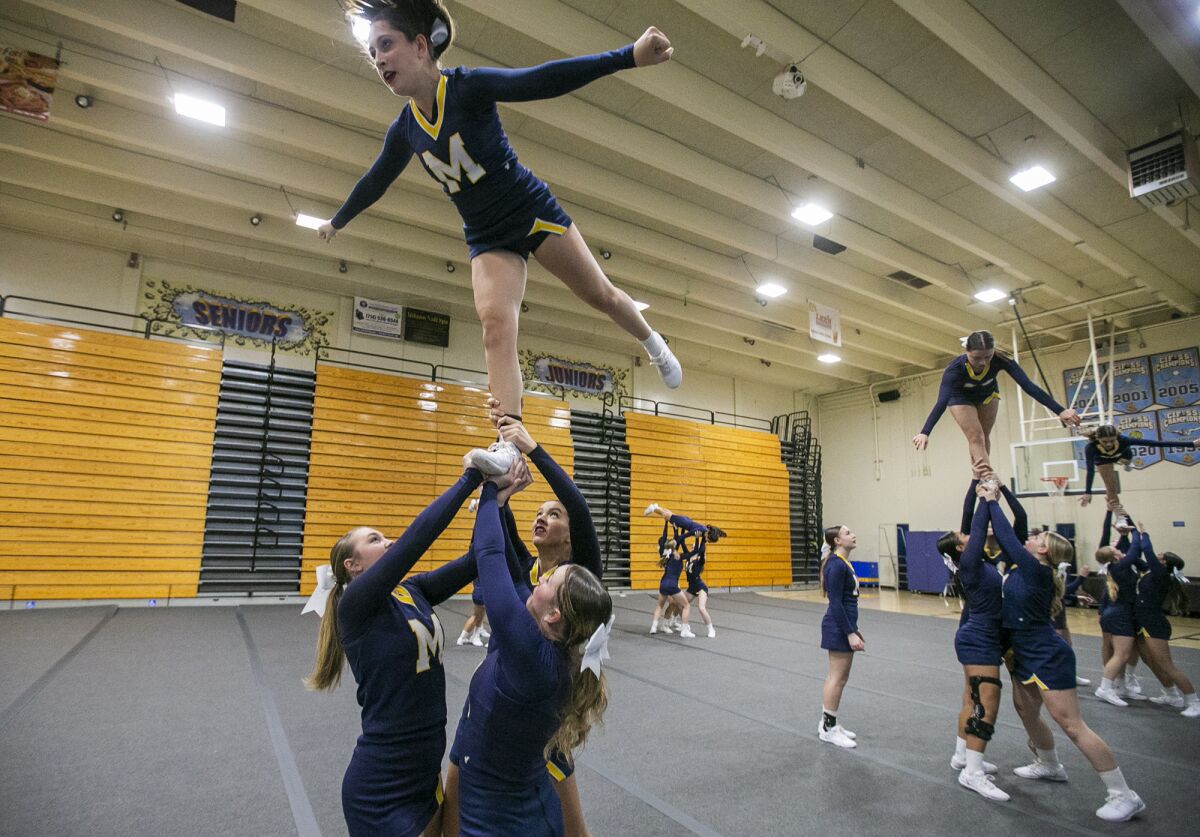 Members of the Marina High cheerleading team practice on Monday in Huntington Beach.