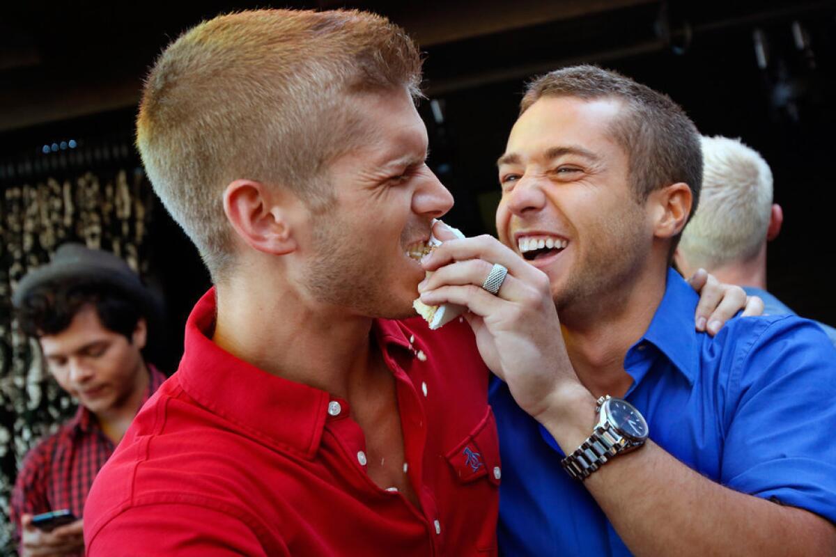 Brandon Brown, 28, left, gets a piece of cake from Colby Melvin, 25, as they celebrate Supreme Court decision to strike down a key part of the federal Defense of Marriage Act overturning of California's Proposition 8 goes on at The Abby Food and Bar in West Hollywood.