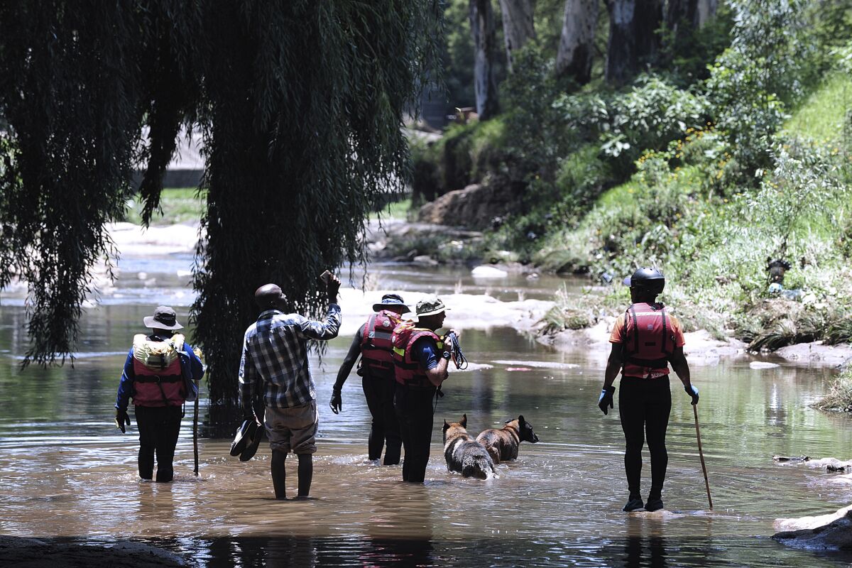 Rescue workers wading through Jukskei River in Johannesburg