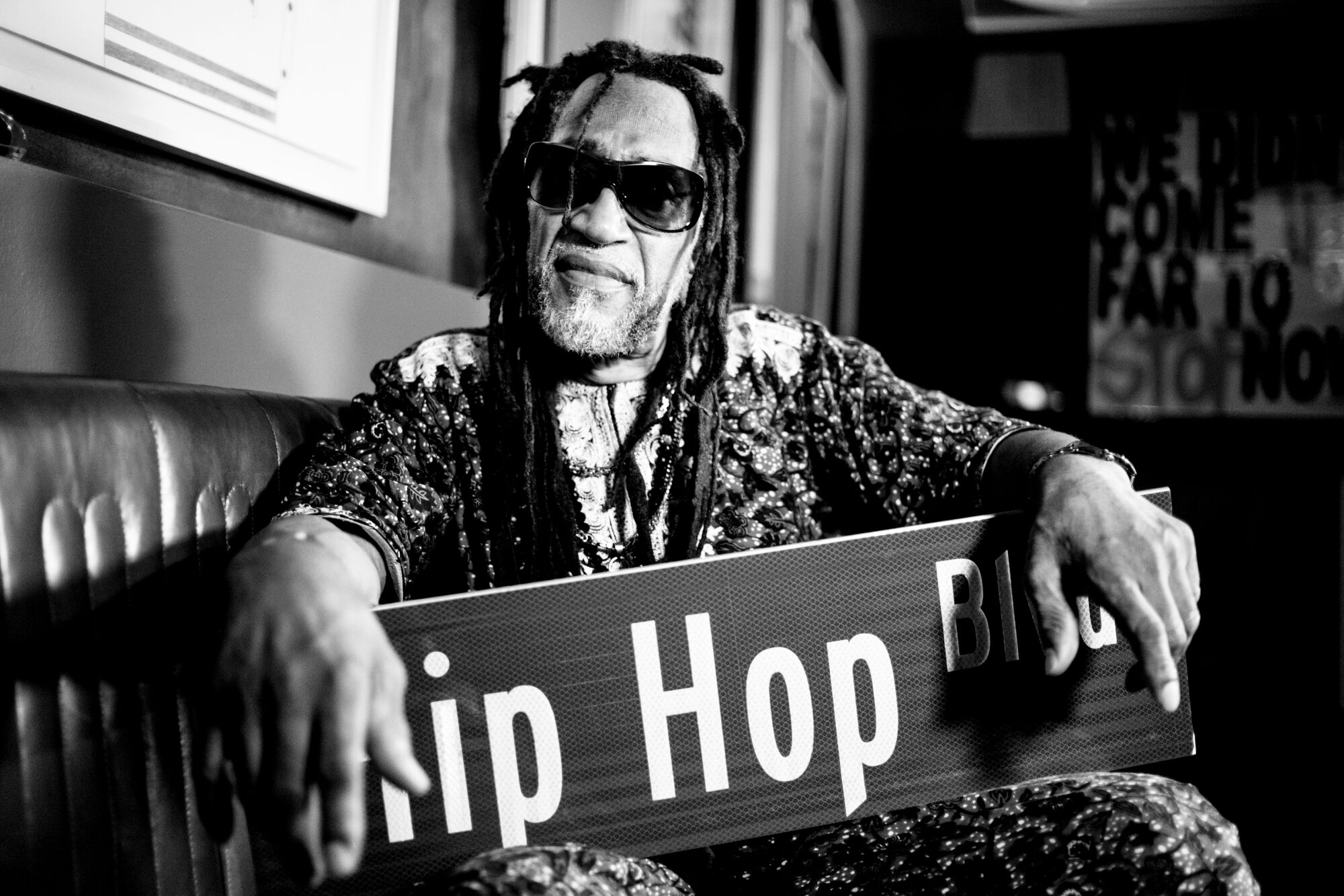 DJ Kool Herc holds a street sign that reads "Hip Hop Blvd."